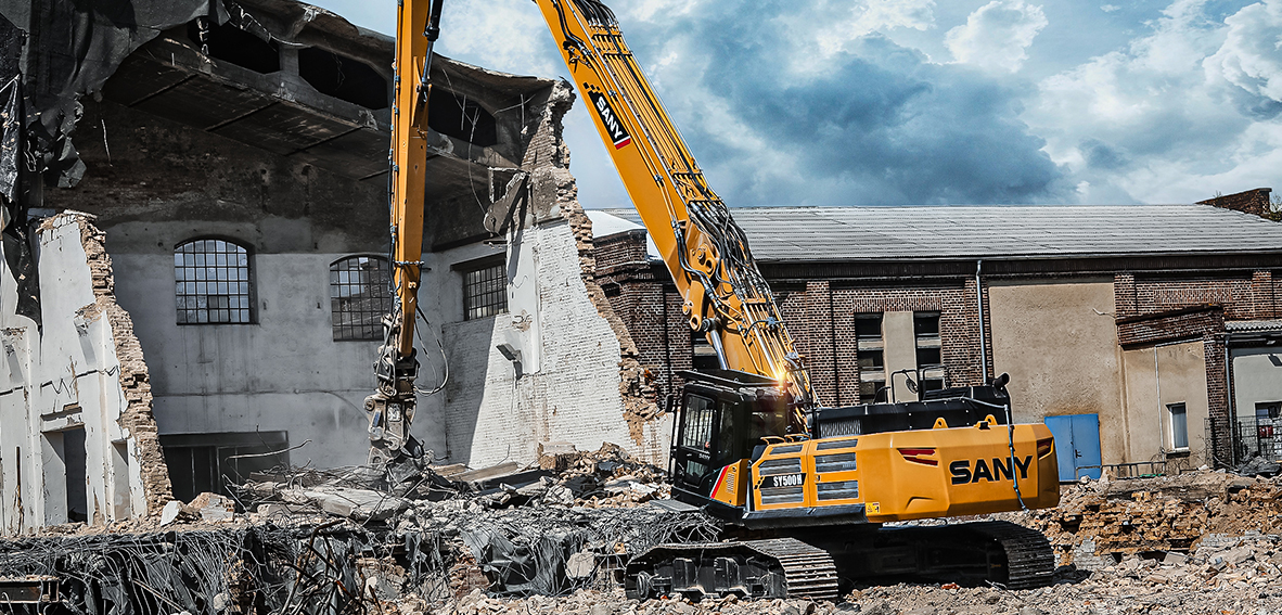 Gelber SANY-Abbruchbagger mit Langfrontausleger und Abbruchzange beim Rückbau einer Industriehalle